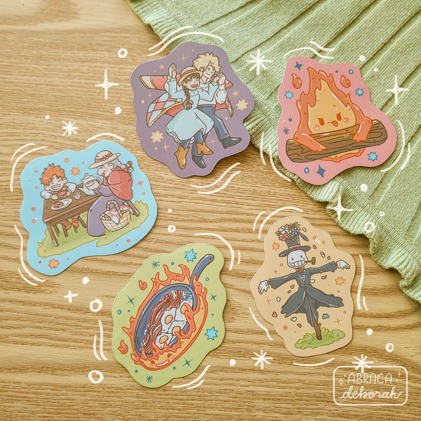 Five colourful stickers depicting different characters including a fire, a scarecrow, a couple, and an elderly woman with a child.