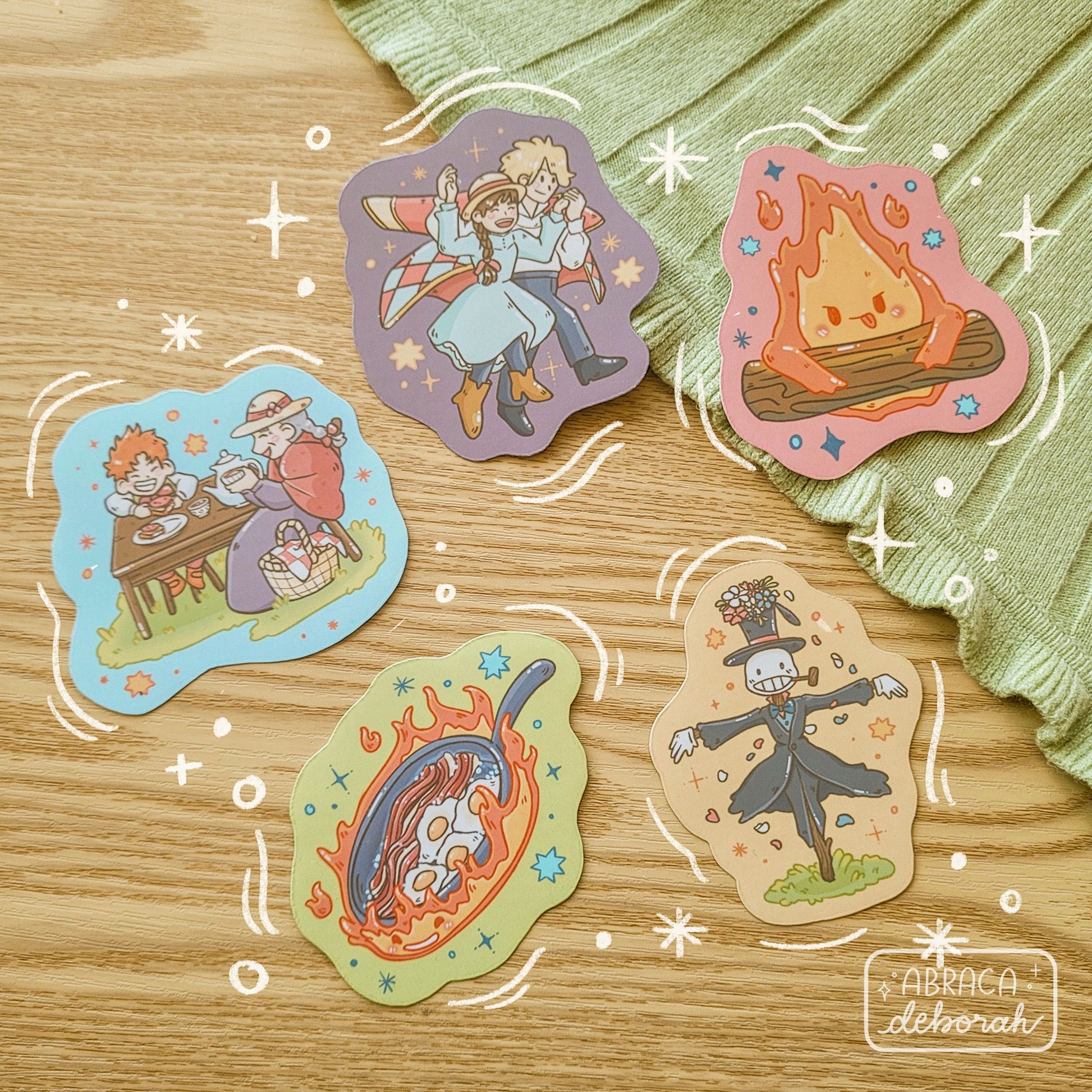 Five colourful stickers depicting different characters including a fire, a scarecrow, a couple, and an elderly woman with a child.