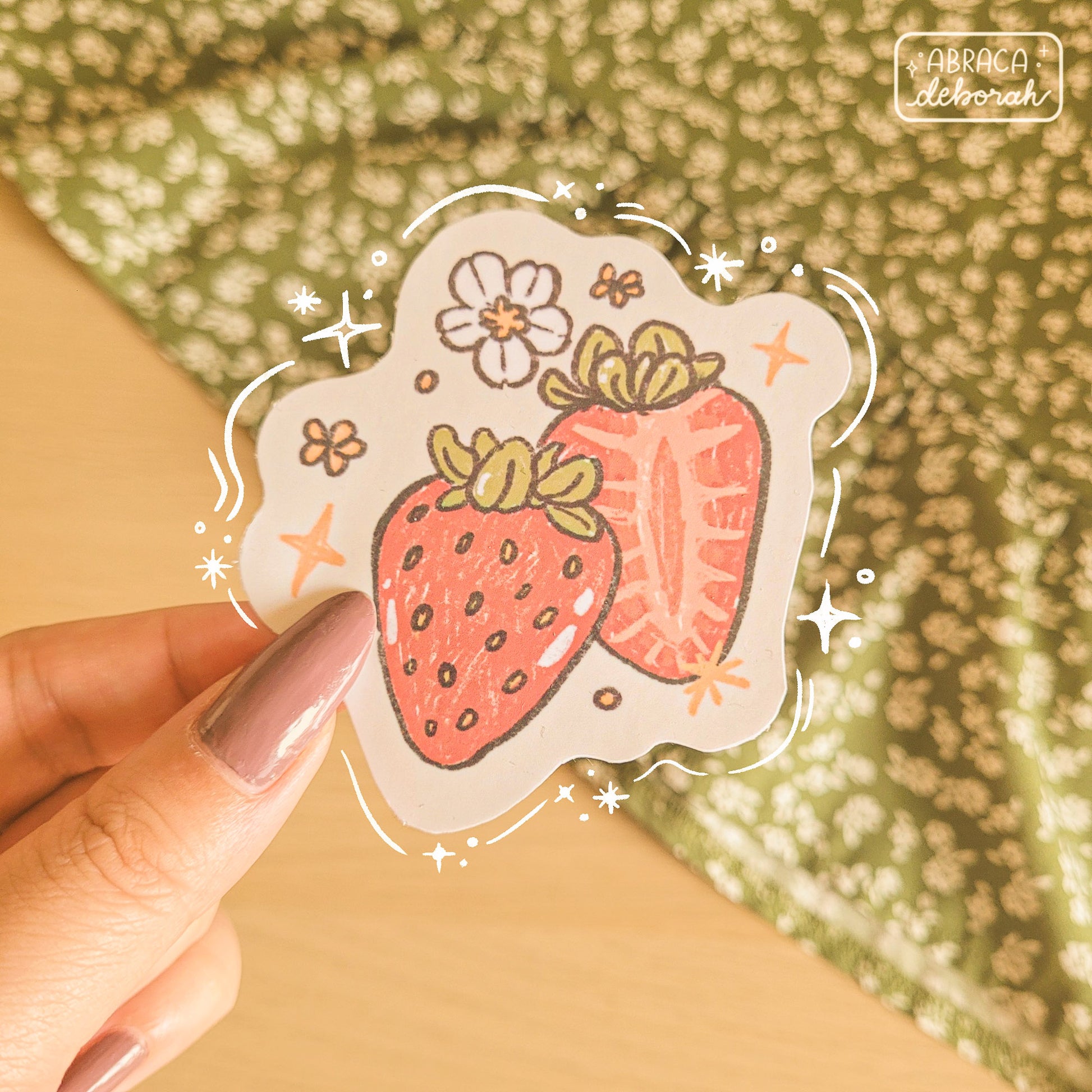 Stickers of two strawberries and a small white flower.
