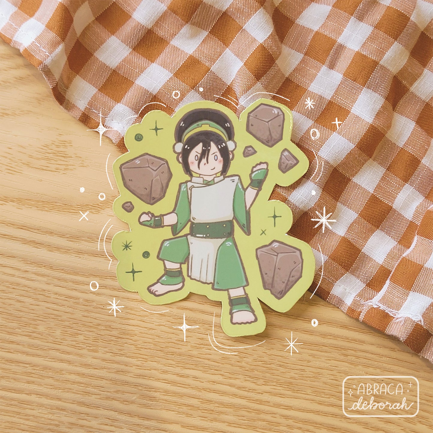 Sticker of a blind girl with rocks floating around her.