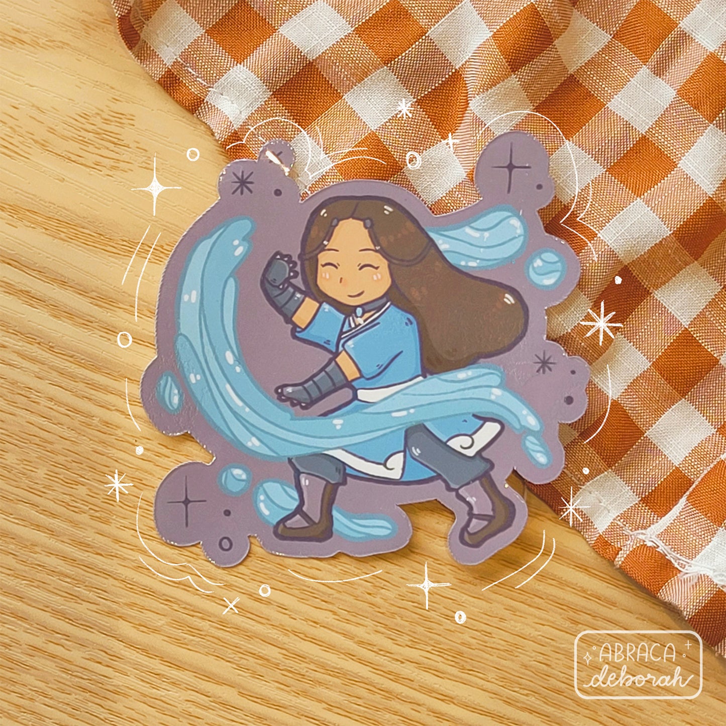 Sticker depicting a girl dressed in blue, moving water with her hands.