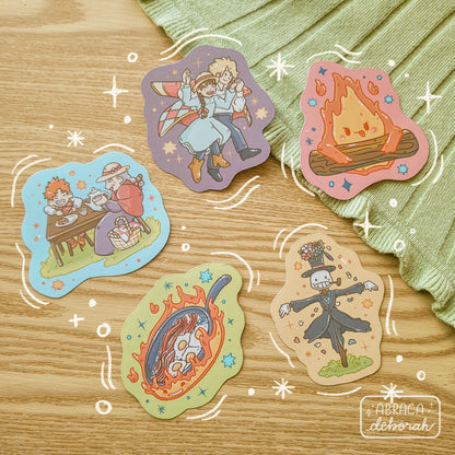 Five colourful stickers depicting different characters including a fire, a scarecrow, a couple, and an elderly woman with a child.