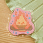 Sticker depicting a cheeky fire holding onto a log.