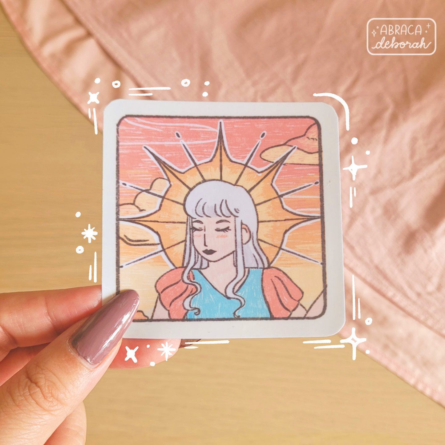 Square sticker of a woman's face. Her eyes are closed, and the sun crowns her head behind her.