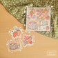 A square print with a collage of strawberries, swords and cake. Three stickers: strawberries, swords, and a cake.