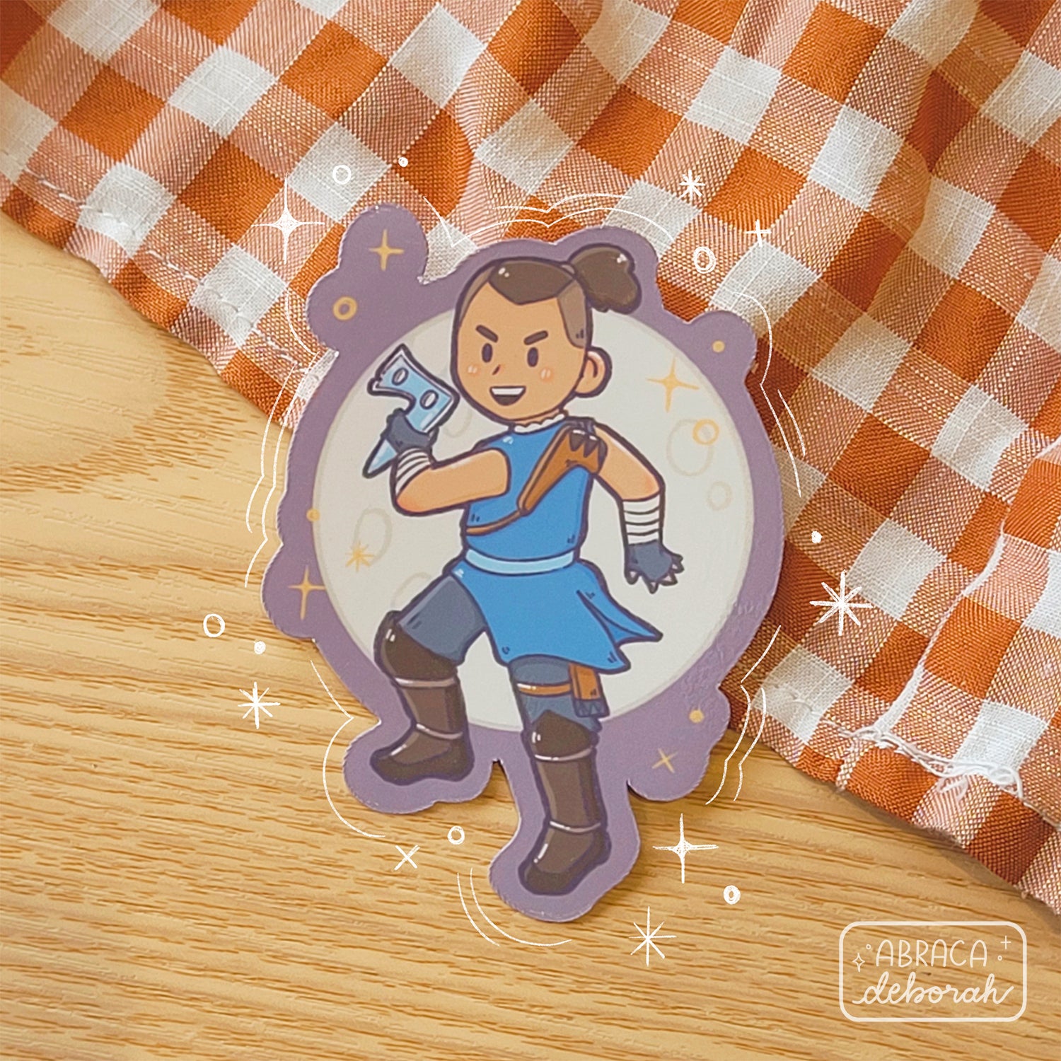 A sticker depicting a male character holding a boomerang as if he is about to throw it. There is a full moon behind him.