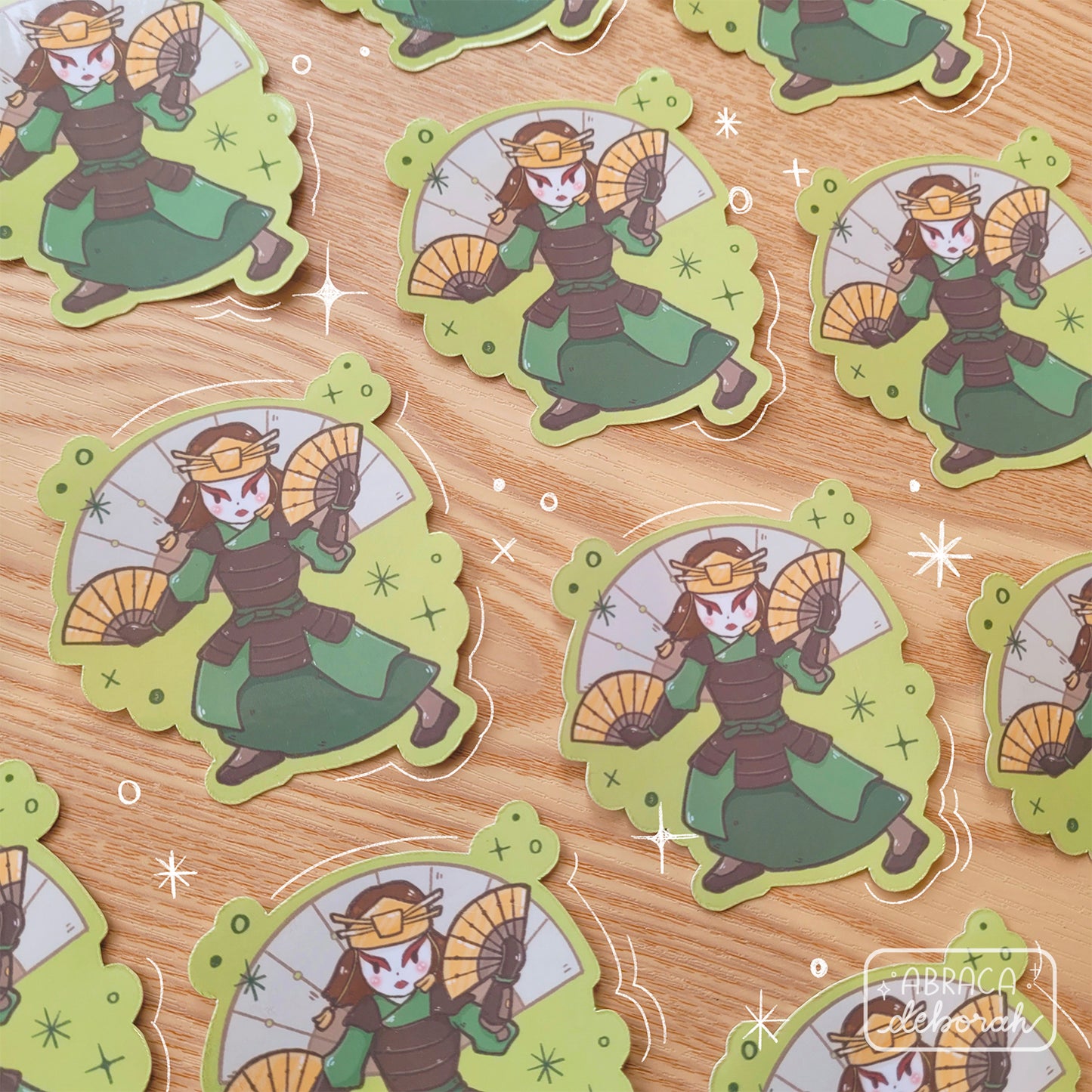 Stickers depicting a female warrior branding two metal fans.